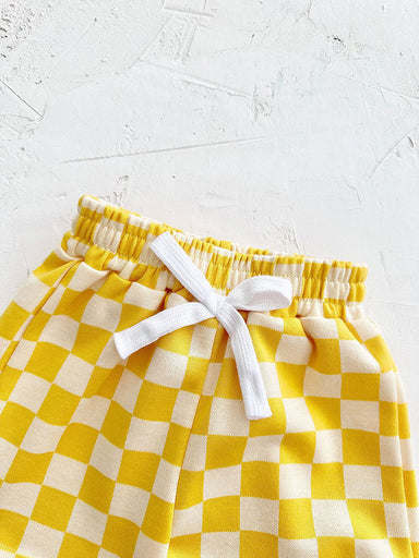 Mellow Mini kledingset 0-3 jaar: T-shirt en geblokte broek in geel, blauw, paars of groen. Duurzaam, comfortabel en perfect voor de zomer! MoreForMini